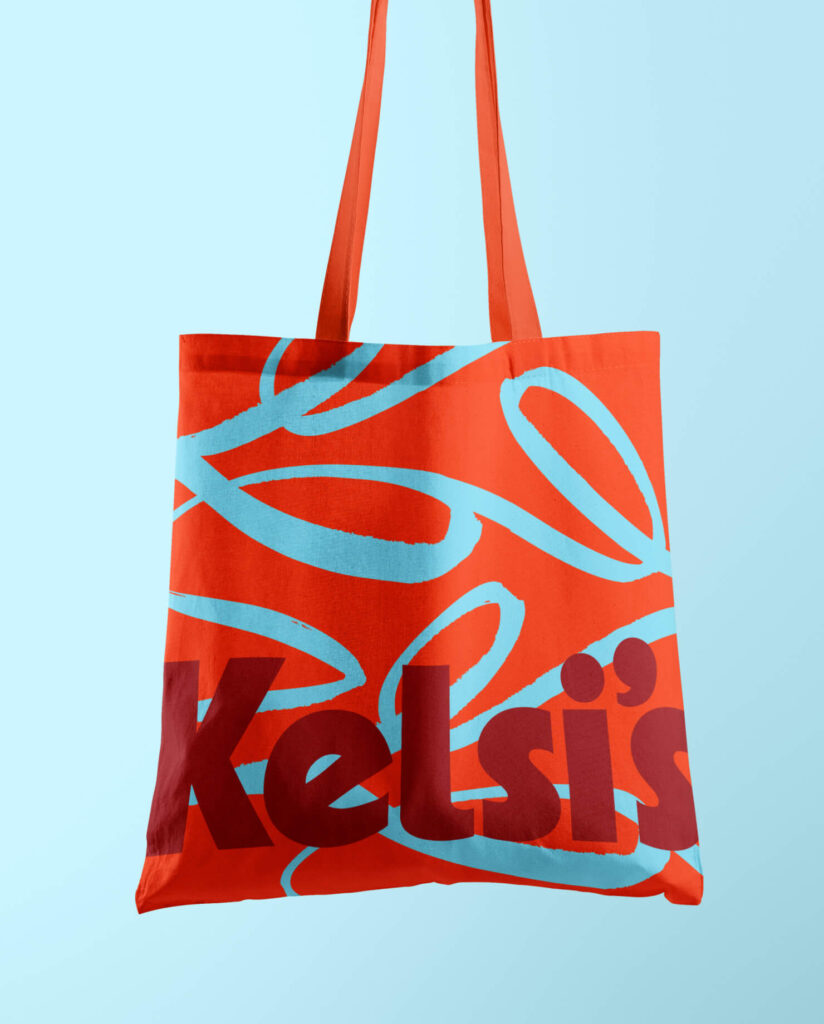 Kelsi's Kitchen bag in a bright red and blue color.